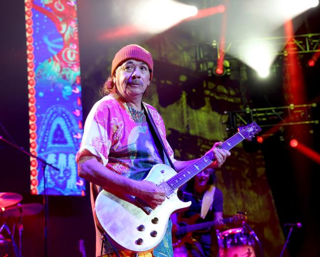 Carlos Santana tocando la guitarra en el escenario
