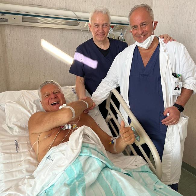 Serafina restaurador Vittorio Assaf acostado en una cama de hospital estrechando la mano de un médico
