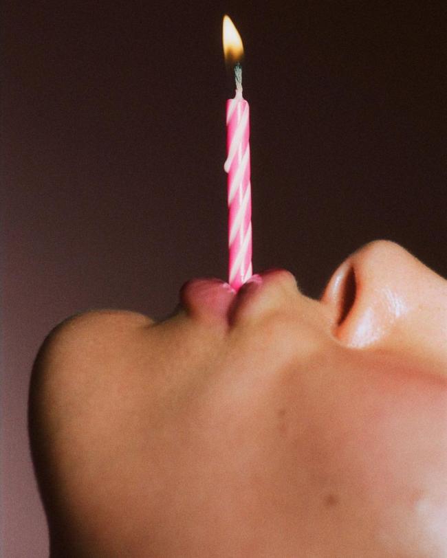 La estrella sostuvo una vela de cumpleaños rosa en su boca para marcar el hito de un año de la marca.