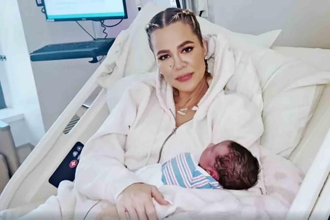 khloé kardashian cargando a su hijo recién nacido en una cama de hospital