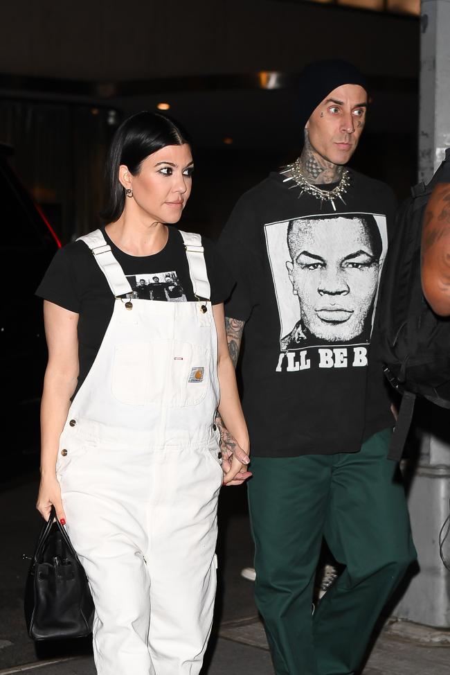 Salió con su esposo, Travis Barker, en un mono blanco de Carhartt con una camisa de banda negra.