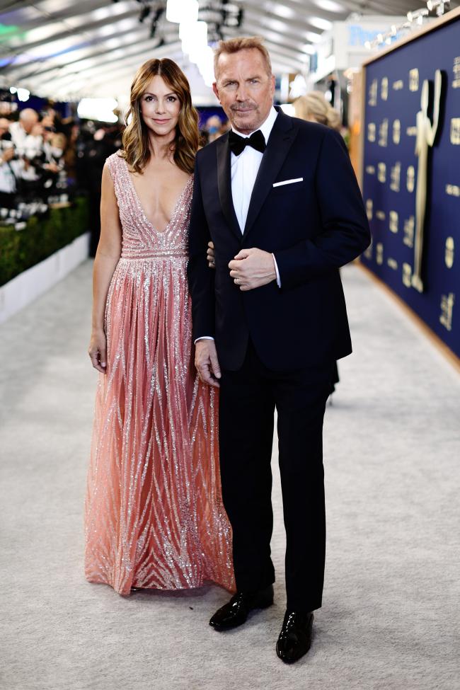 Kevin Costner y Christine Baumgartner juntos en la alfombra roja.