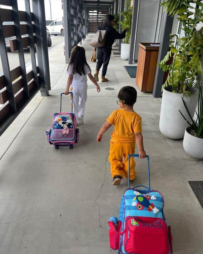 Los dos hijos de Mindy Kaling empujando maletas