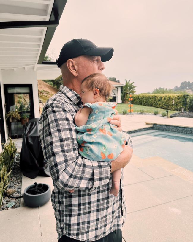 Bruce Willis cargando a su nieta.