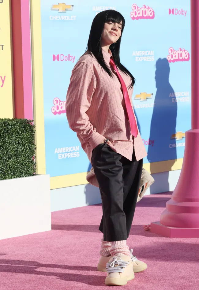 Eilish usó una camisa rosa y una corbata junto con un par de zapatillas de deporte caricaturescamente grandes en el estreno de 