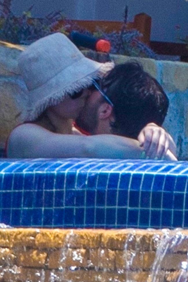 La pareja rumoreada fue fotografiada besándose mientras estaba en la piscina.