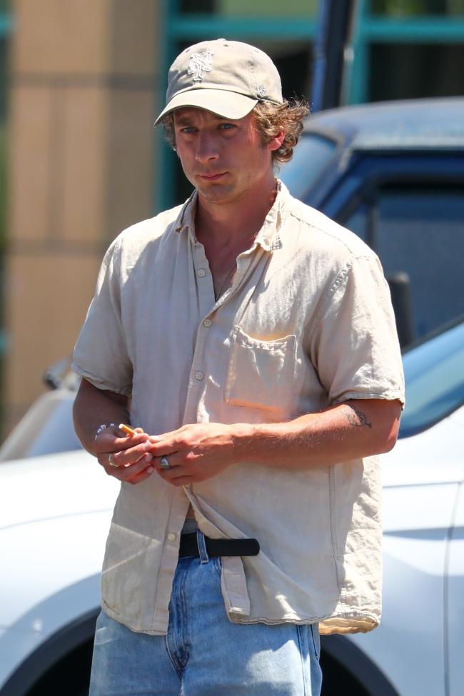 jeremy allen white caminando en un estacionamiento