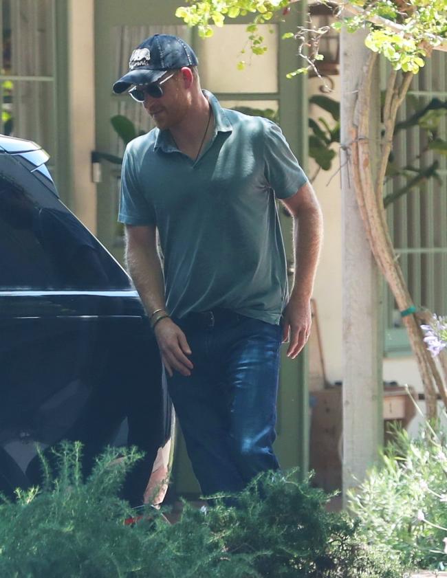 El príncipe Harry se veía casual con una camisa polo y jeans.