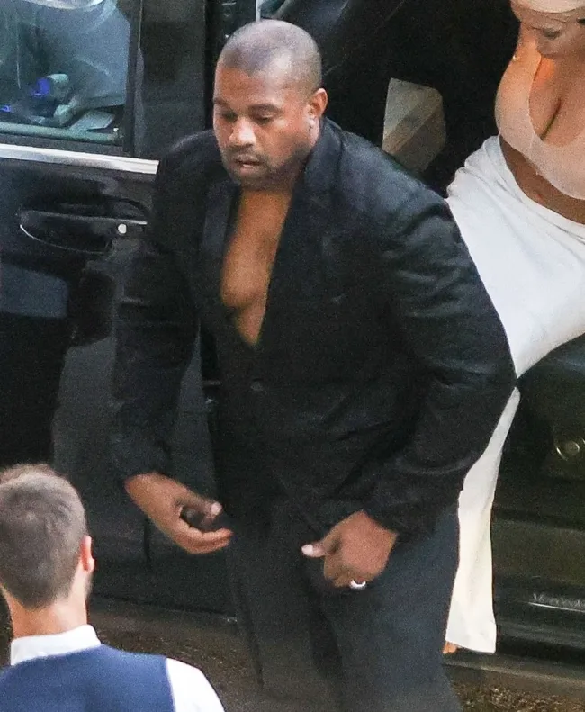 West lucía un blazer negro mal ajustado sin camisa debajo y pantalones a juego.
