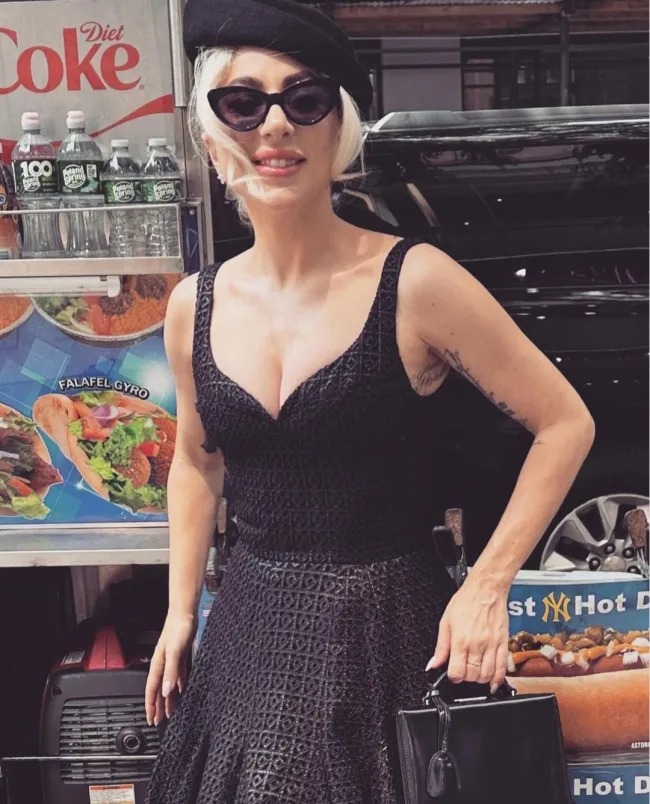 Junto al pie de foto, la cantante publicó tres fotos en las que se la ve luciendo un vestido negro, una boina negra, gafas de sol y un bolso negro, sentada frente a un carrito de comida.