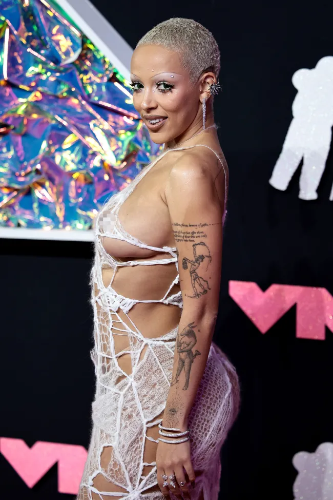 El vestido de punto apenas visible mostraba los controvertidos tatuajes del rapero de “Attention”.