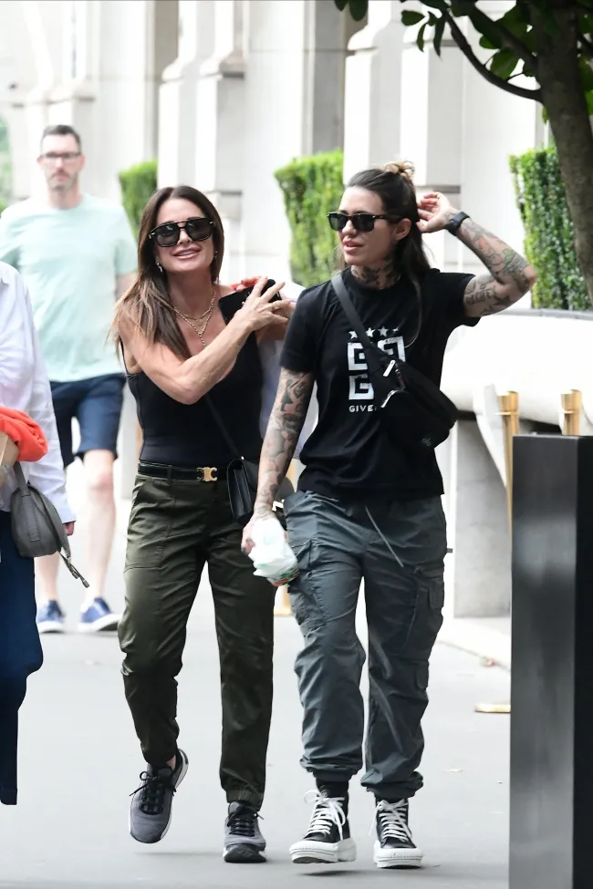 La estrella de “Real Housewives of Beverly Hills”, que vestía un mono escotado, llevaba un par de bolsas de compras al hombro.