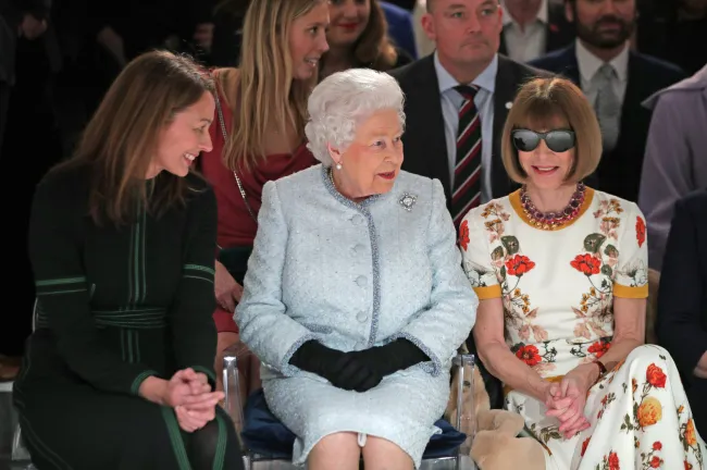 Caroline Rush, directora ejecutiva del British Fashion Council, se sentó al otro lado de la reina Isabel en el desfile.