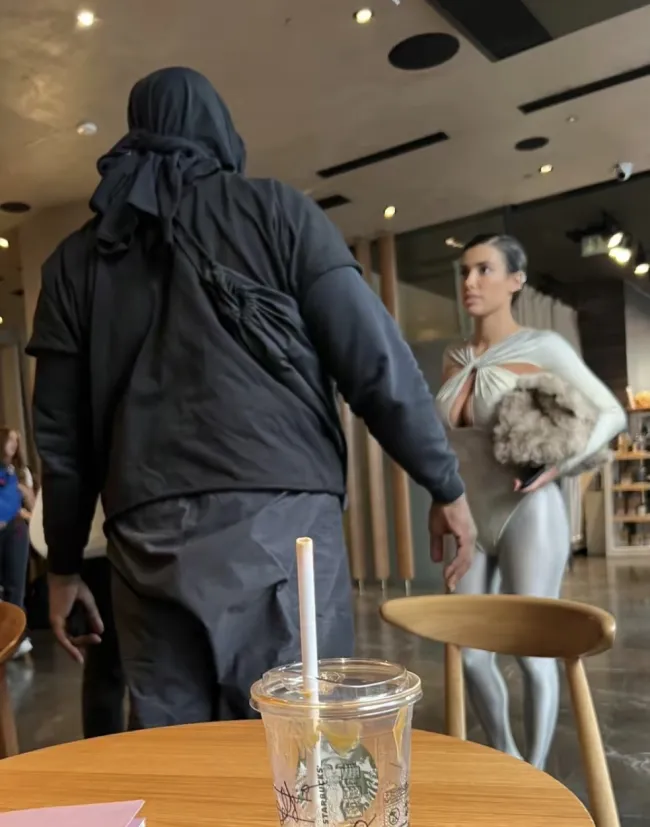 Bianca Censori mostró un escote con un body plateado combinado con medias mientras visitaba un Starbucks de Milán con Kanye West.