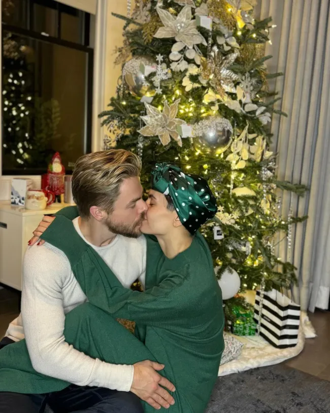 Hayley Erbert y Derek Hough besándose frente al árbol de Navidad