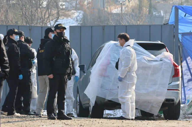 La policía cubre un vehículo en la escena de un crimen en Corea del Sur.