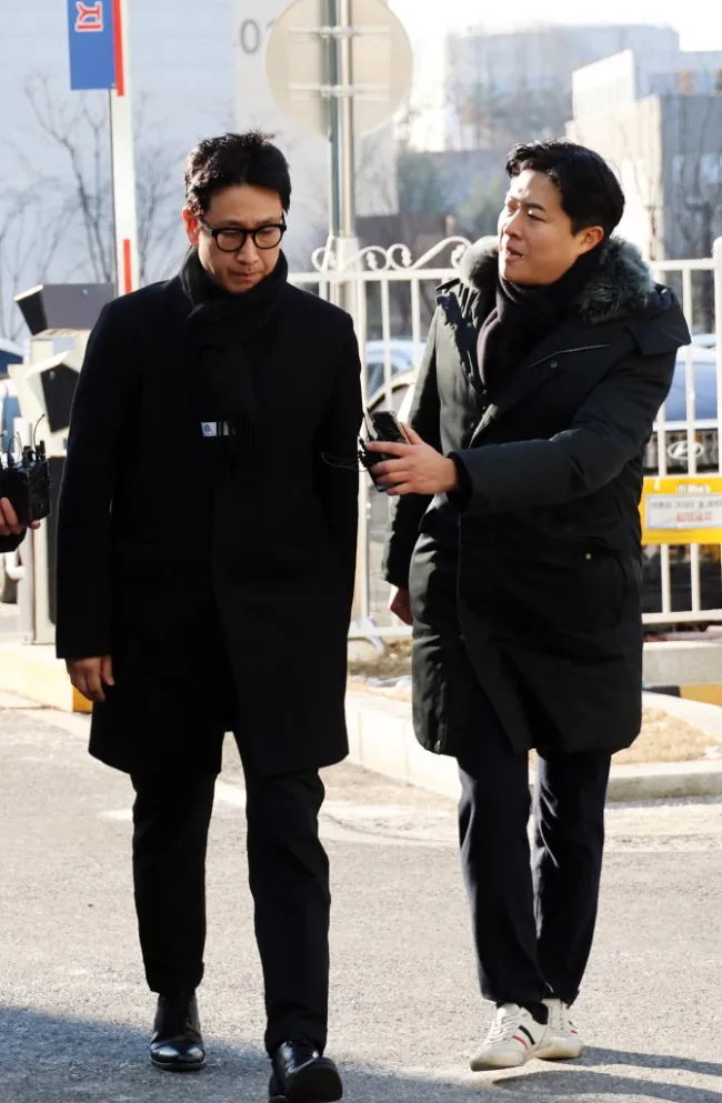 Lee Sun-kyun siendo interrogado por otro hombre con una grabadora