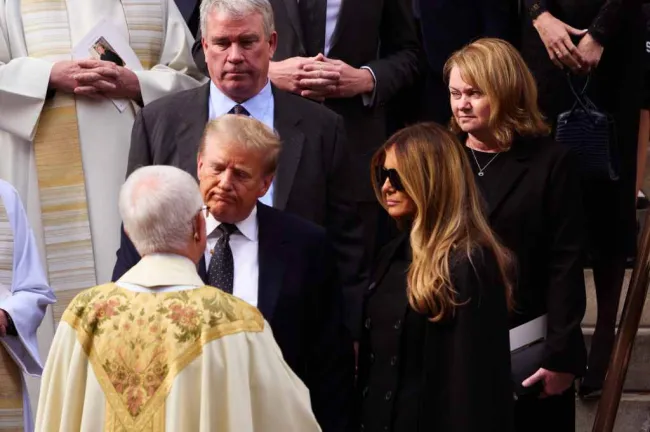 El presidente Donald Trump y su esposa Melania Trump hablando con el sacerdote en un funeral