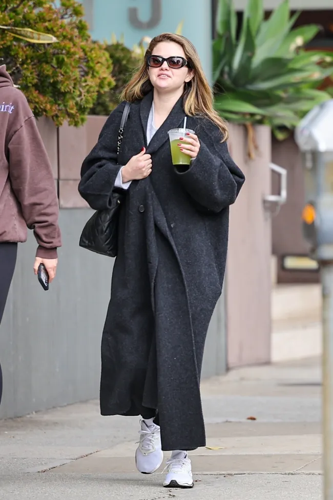 Selena Gomez usó un abrigo de diseñador de lujo con ropa deportiva mientras salía con una amiga a Los Ángeles el martes.