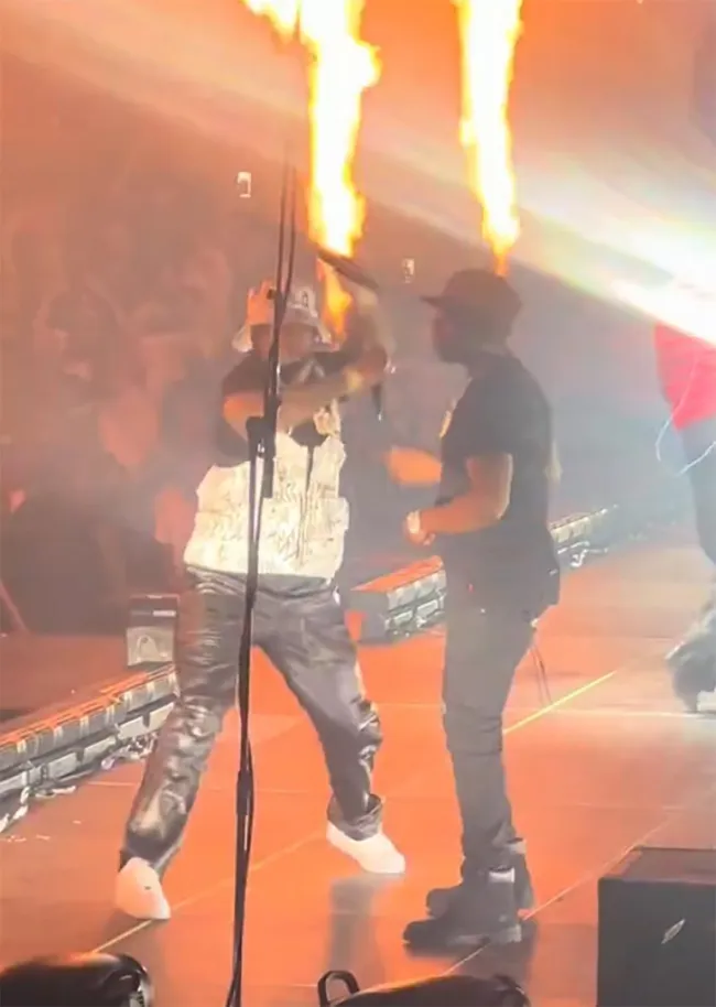50 cent con otro hombre en el escenario con fuego durante un concierto