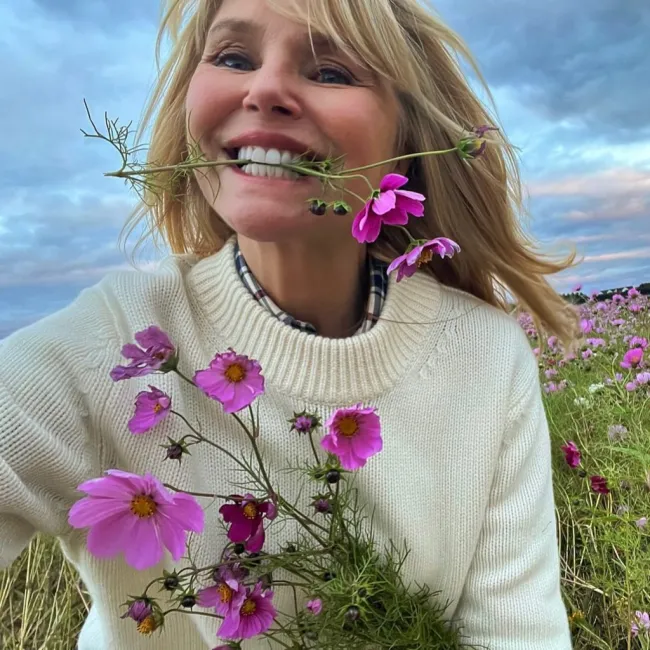 Christie Brinkley sonriendo con flores