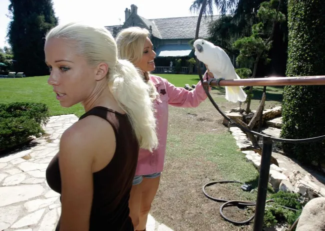 Las novias de Hugh Hefner con un pájaro.