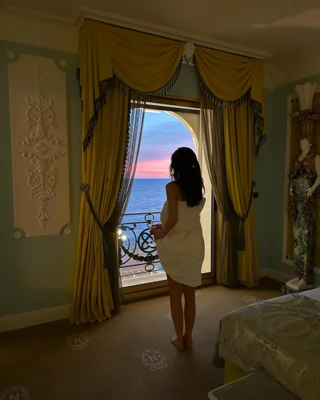 Kylie Jenner mirando por la ventana de un hotel