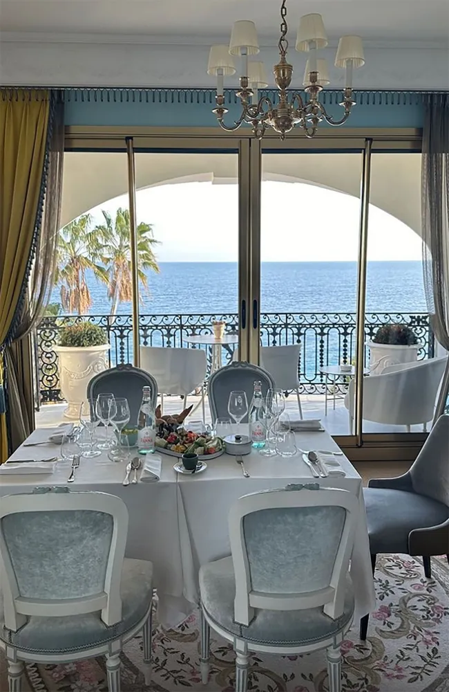 Una mesa puesta dentro de una habitación de hotel con vista al océano.