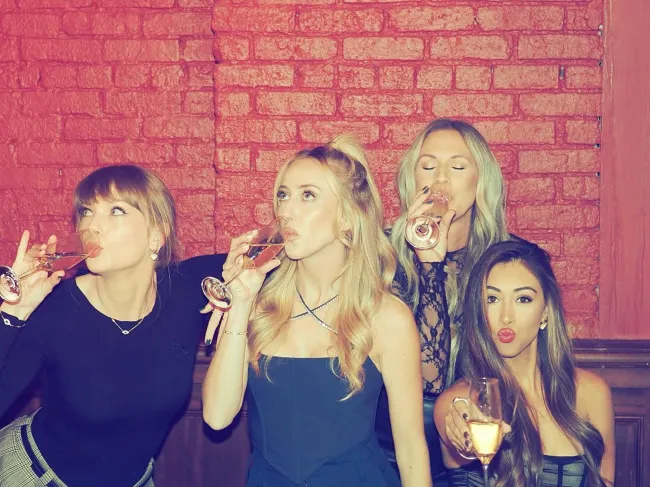 Taylor Swift bebiendo cócteles con amigos.