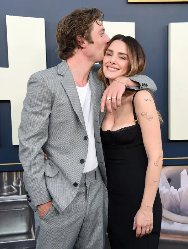 Jeremy Allen White besando la cabeza de Addison Timlin, mientras está en la alfombra roja