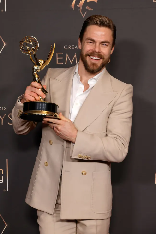 Derek Hough sosteniendo un Emmy