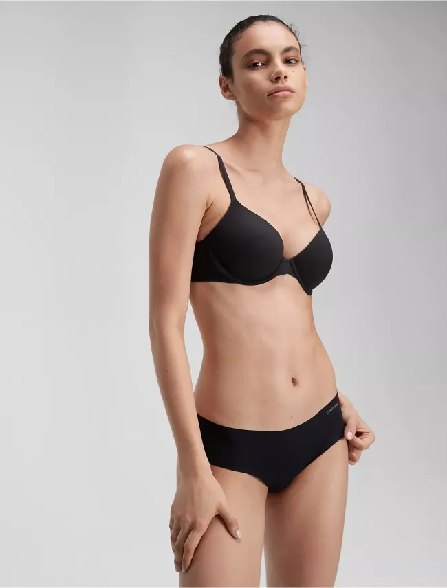 Una modelo con sujetador y braguitas negras de Calvin Klein.