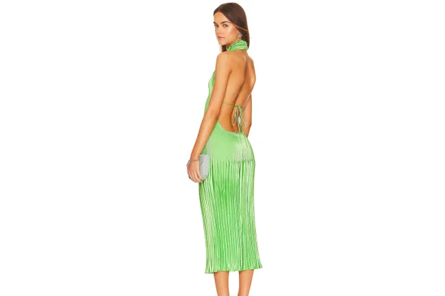 Una modelo con un vestido verde sin espalda.
