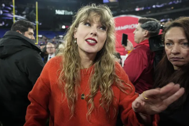 Taylor Swift habla con la gente en el campo después de un partido de fútbol americano de la NFL por el Campeonato de la AFC entre los Baltimore Ravens y los Kansas City Chiefs, el domingo 28 de enero de 2024, en Baltimore.