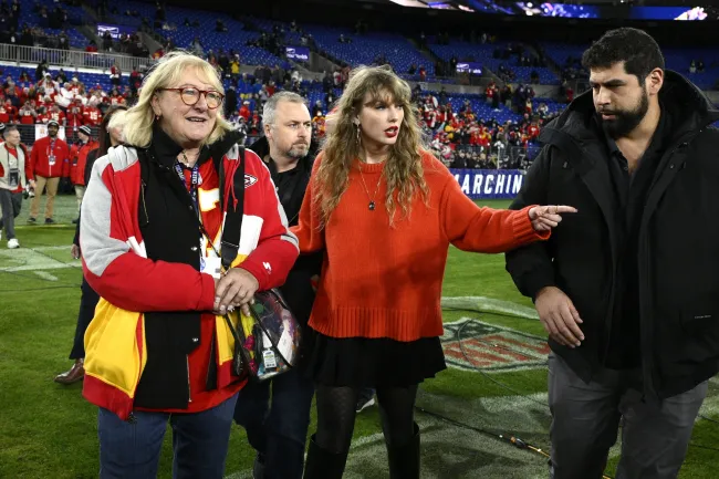Taylor Swift, centro, y Donna Kelce caminan por el campo después de que los Kansas City Chiefs ganaron el partido de fútbol americano de la NFL por el Campeonato de la AFC contra los Baltimore Ravens, el domingo 28 de enero de 2024, en Baltimore.