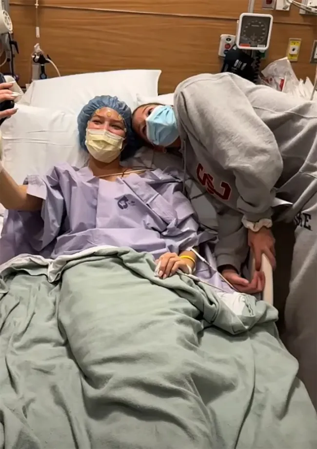 isabella strahan acostada en una cama de hospital tomándose una selfie con su gemela sophia