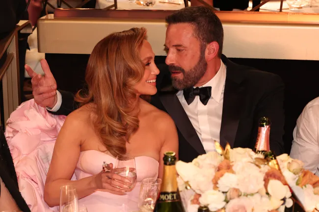 Ben Affleck y Jennifer Lopez sentados en los Globos de Oro 2024