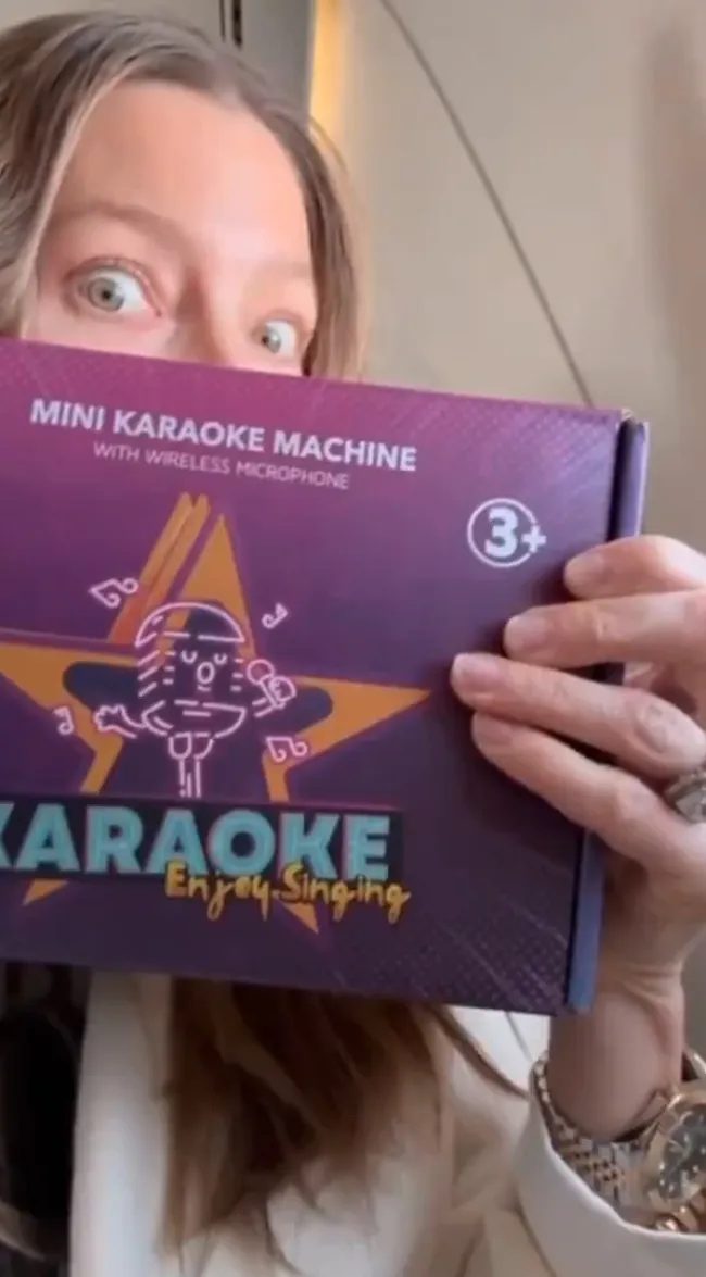 Jessica Biel sosteniendo una caja de máquina de karaoke.