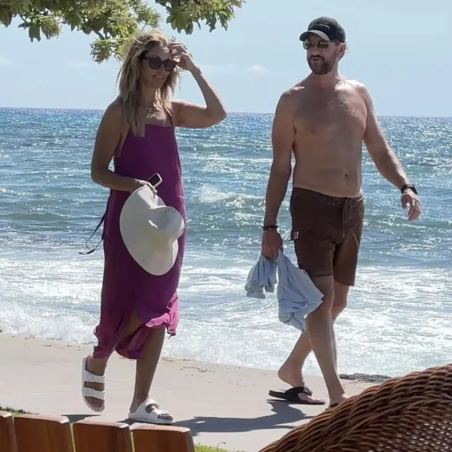christine baumgartner y josh connor caminando por la playa