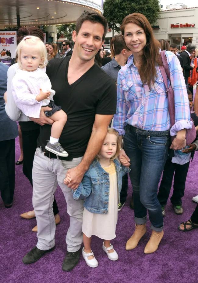 Christian Oliver y Jessica Klepser con sus hijas en una alfombra roja.