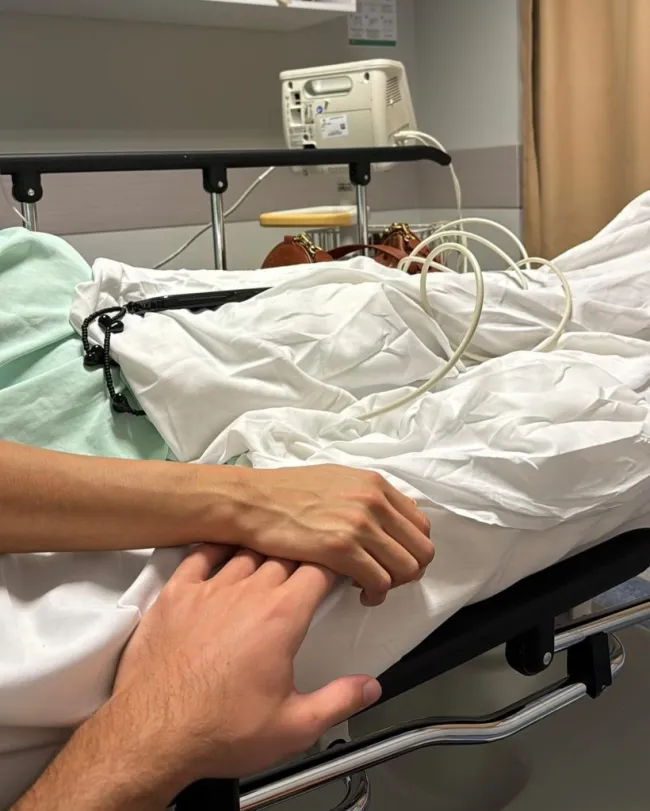 un hombre sosteniendo la mano de una mujer en una cama de hospital