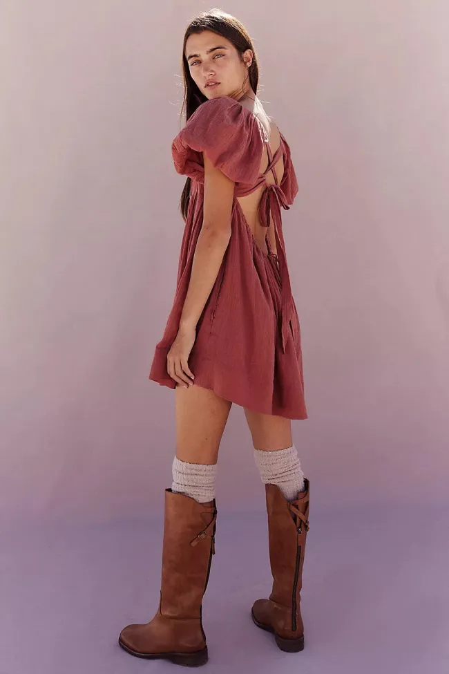Una modelo con un minivestido rosa sin espalda.