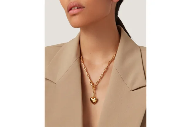 Una modelo con blazer y collar de cadena de oro.