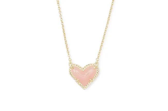 Un collar con colgante de corazón rosa y dorado.