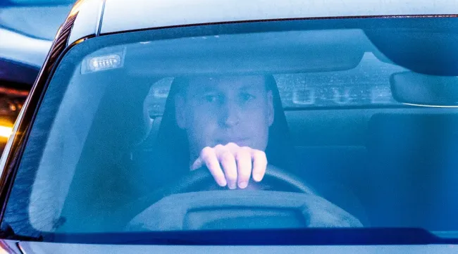 El príncipe William al volante de su automóvil, visto a través del parabrisas