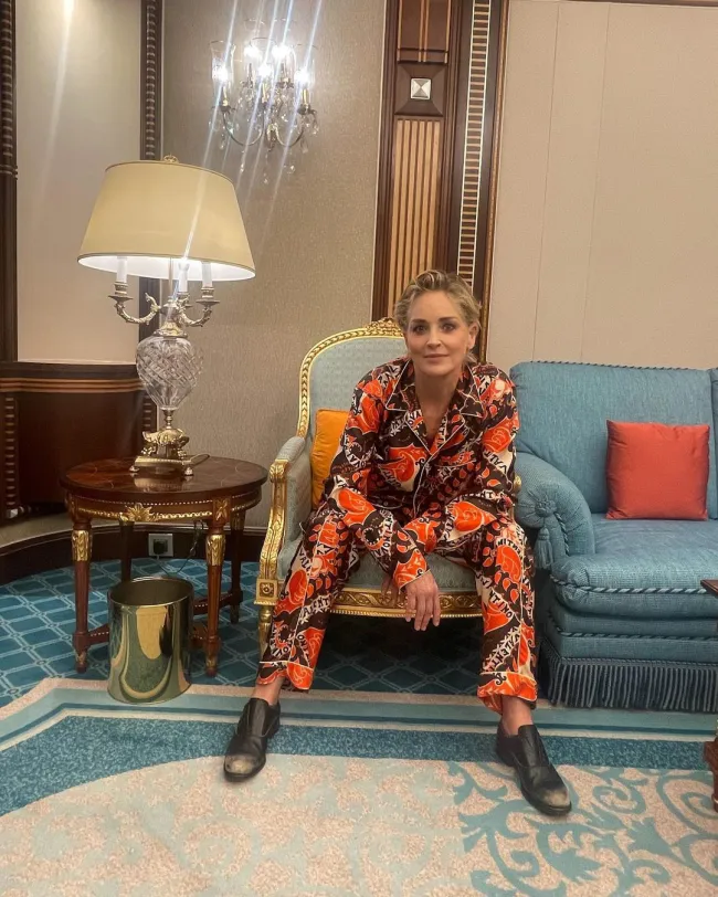 Sharon Stone sentada en un sofá.