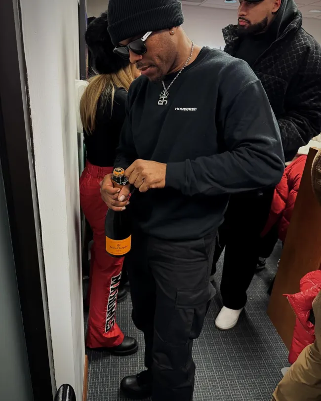 Aric Jones bebiendo champán
