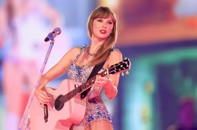 Taylor Swift tocando una guitarra rosa