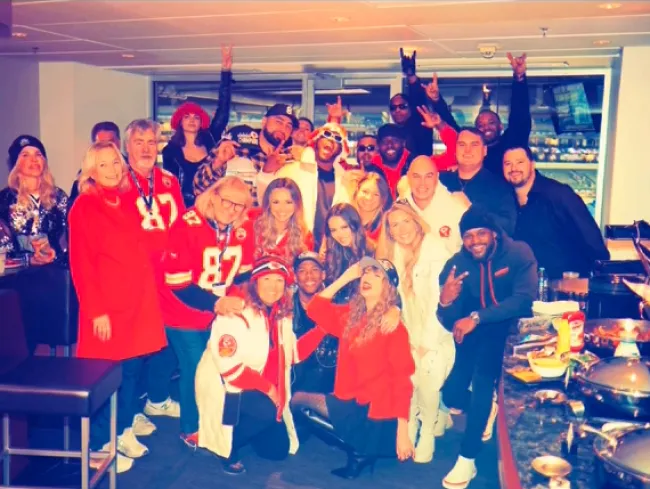 Taylor Swift posando con la familia y amigos de Travis Kelce en el juego de los Chiefs