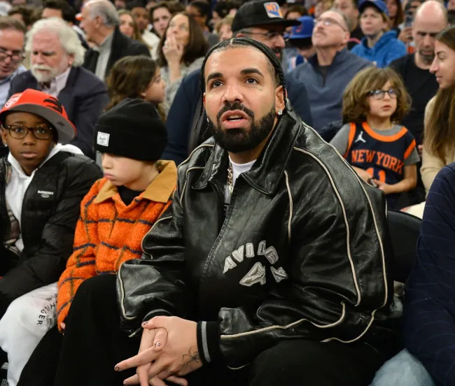 Drake y su hijo Adonis viendo un partido de baloncesto.
